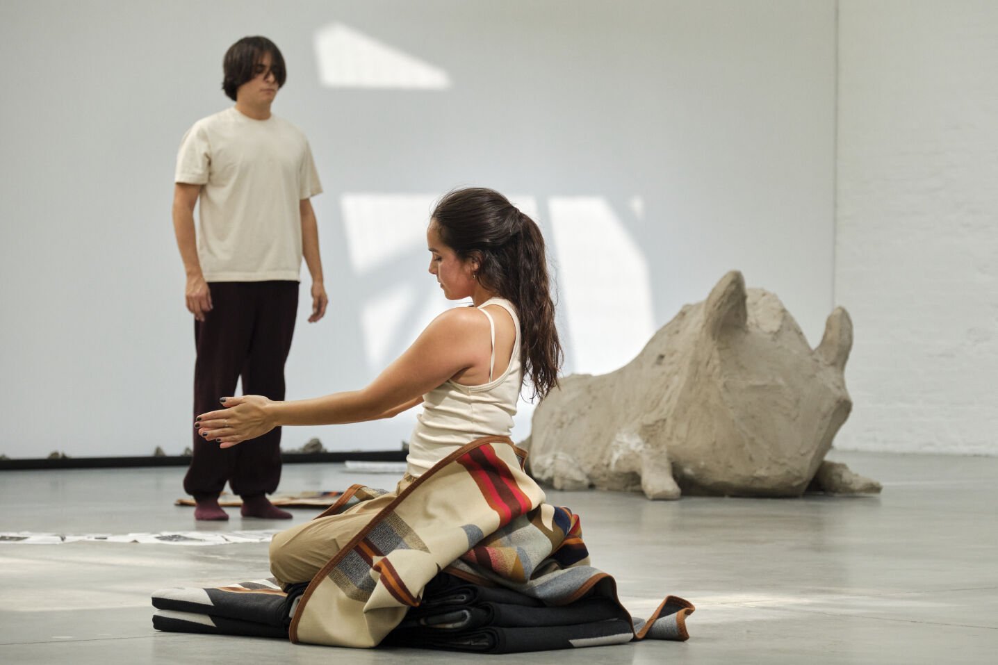 Woman kneels on the floor covered in Pendleton blankets