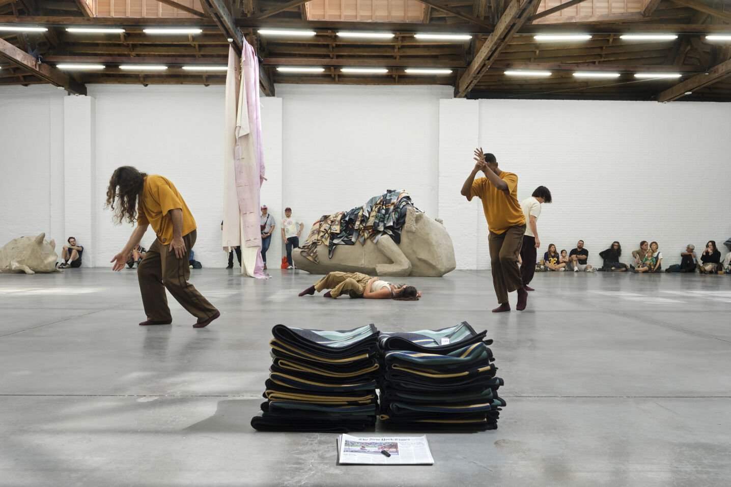 Two dancers perform astride a pile of blankets