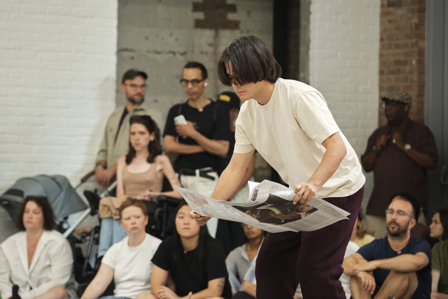 Male performer using newspaper to coat the floor