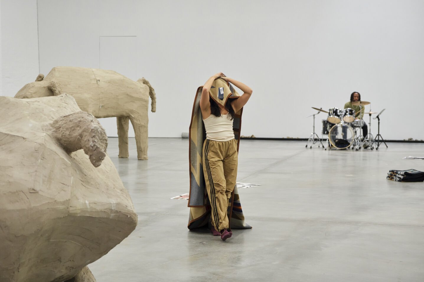 Performance on October 25 of a woman with a blanket covering her face and a drummer behind her.